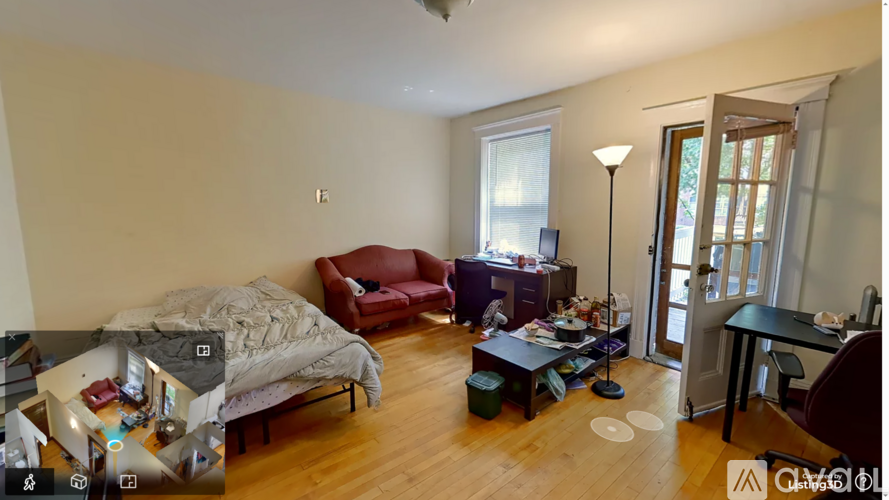 A bedroom with a bed, a couch, a chair, a desk, and a window.