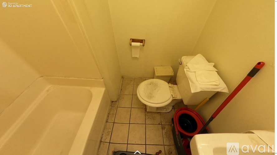 A small bathroom with a toilet, a bathtub, and a trash can.