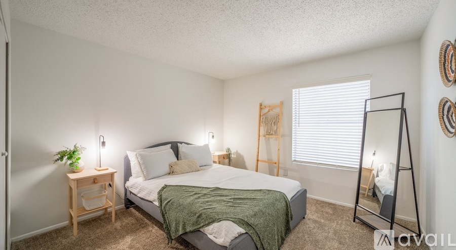 A bedroom with a bed, nightstand, and a mirror.