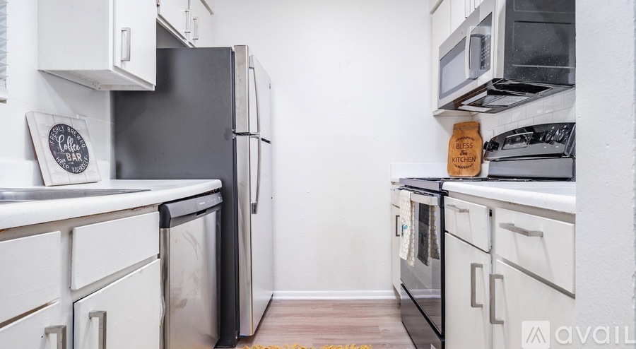 A kitchen with white cabinets and black appliances.