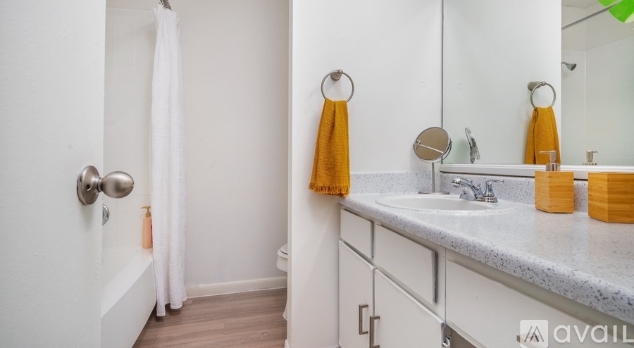 A bathroom with a white sink, a white towel, and a white shower curtain.