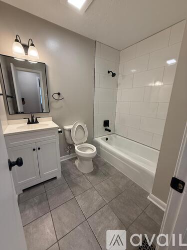 A bathroom with a toilet, sink, and bathtub.