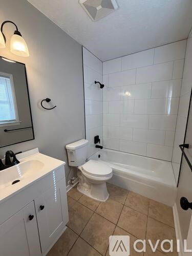 A bathroom with a toilet, sink, and bathtub.