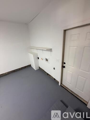 A room with a white door and a white wall.