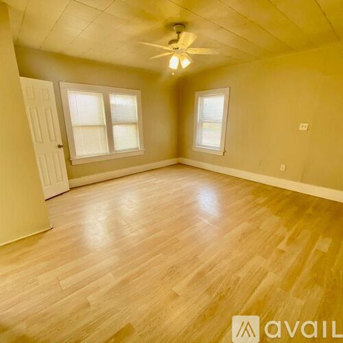 A room with a ceiling fan and a door.