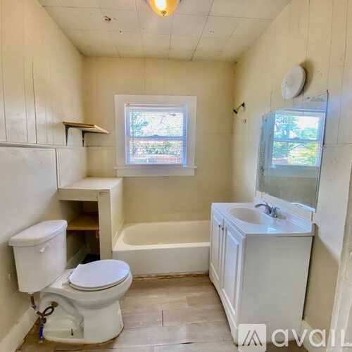 A room with a white door and wooden flooring.