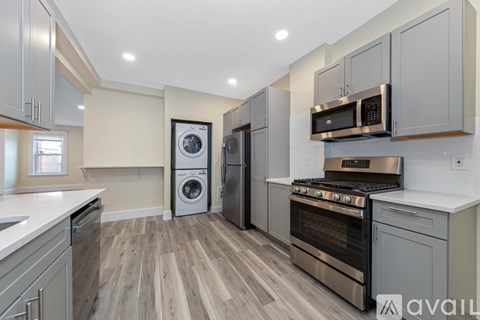 A modern kitchen with a washing machine and a stove top oven.
