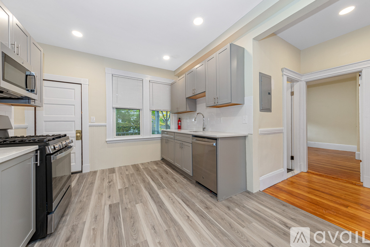 A kitchen with a wood floor and white walls.