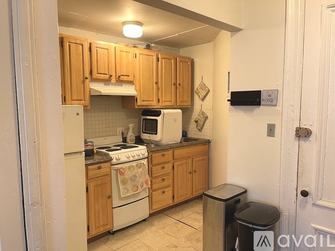 A kitchen with wooden cabinets and a white refrigerator.