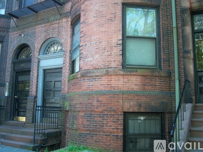 A red brick building with a black door and windows.