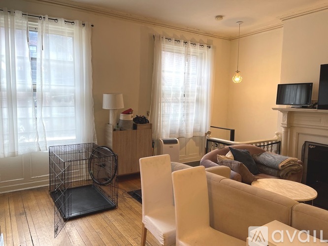 A living room with a couch, chair, and television.