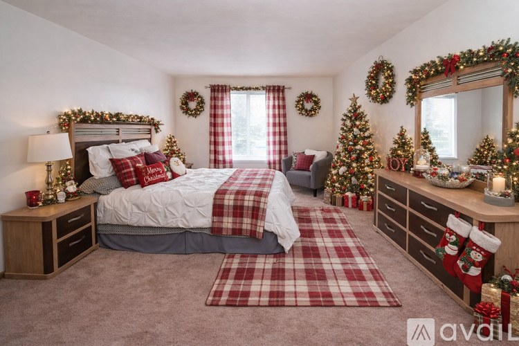 A bedroom decorated for Christmas with a bed, wreaths, stockings, and a Christmas tree.
