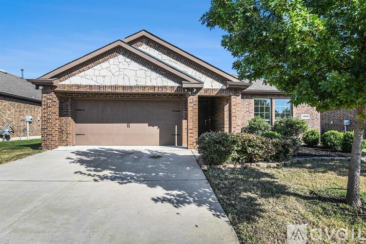 A house with a driveway and a tree in front.