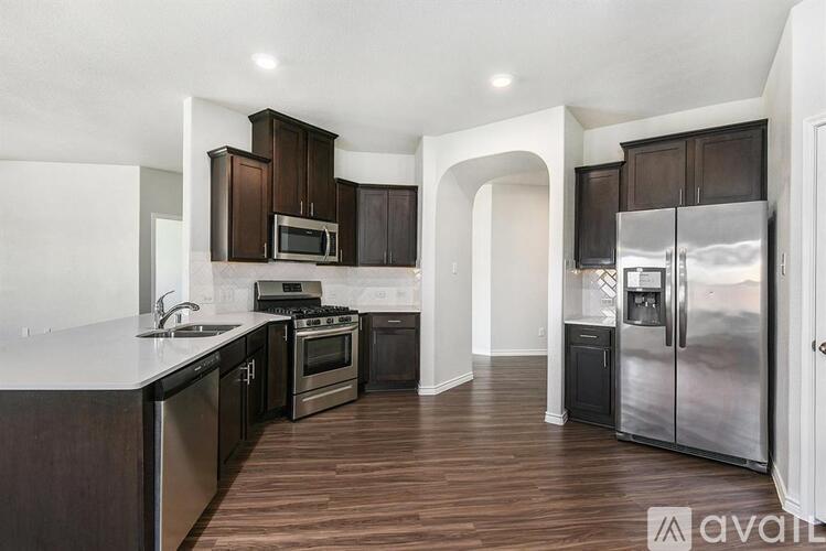 A kitchen with dark wood cabinets and stainless steel appliances.