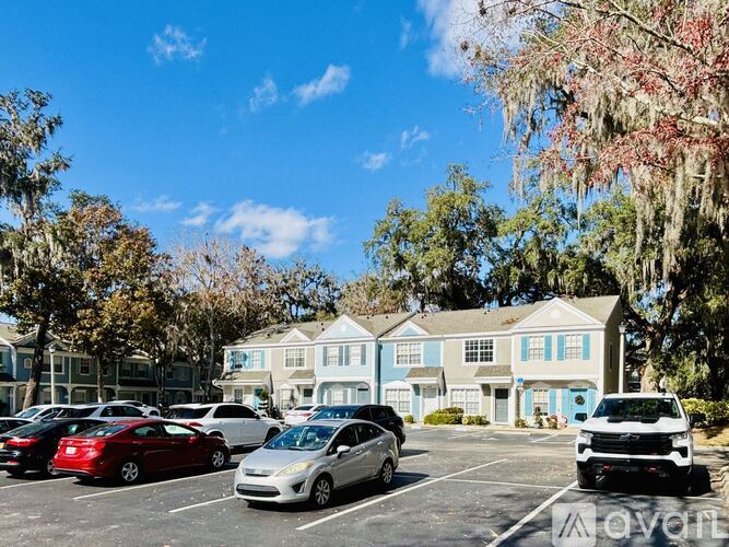 A parking lot with cars and a building in the background.