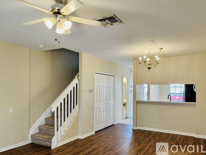 A spacious room with a staircase and a chandelier.