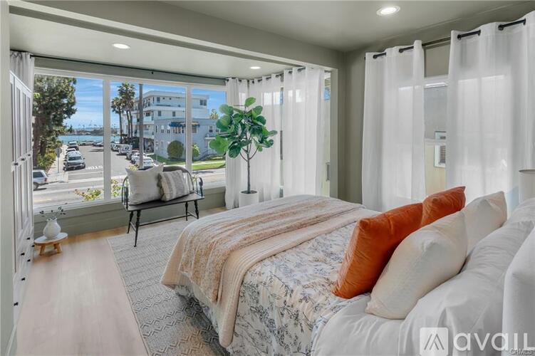 A bedroom with a large bed and a view of the street outside.