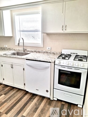 A kitchen with white cabinets and appliances.