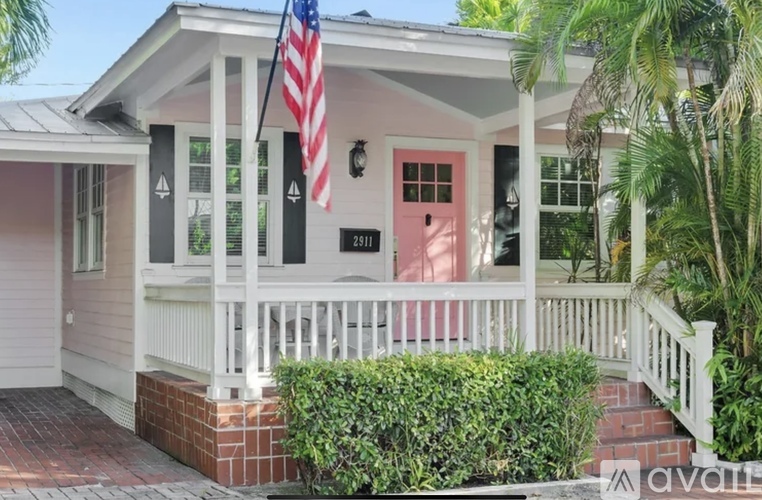 A house with a red door and an American flag on the porch.