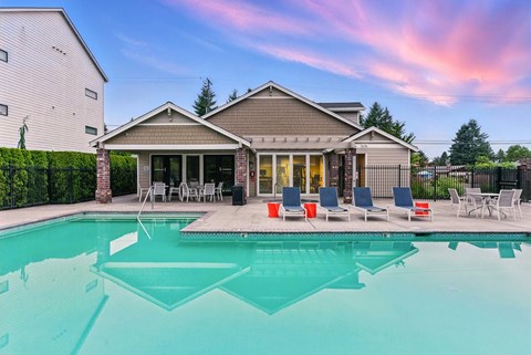 A house with a pool in front of it.