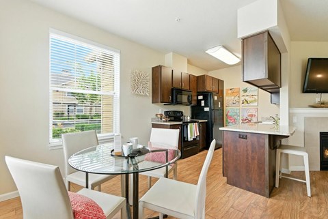 A kitchen with a table and chairs in front of a window.