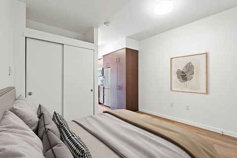 A bedroom with a bed and a painting on the wall.