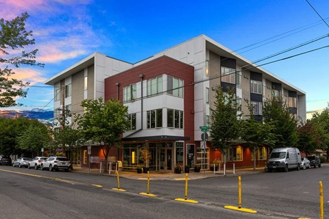 A modern building with a parking lot in front of it.