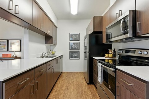 A kitchen with dark wood cabinets and stainless steel appliances.