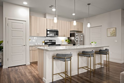 A kitchen with a white counter and two bar stools.