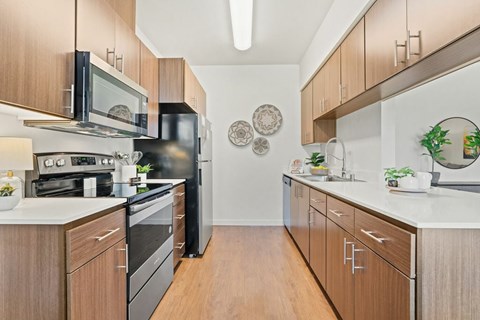 A kitchen with wooden cabinets and black appliances.