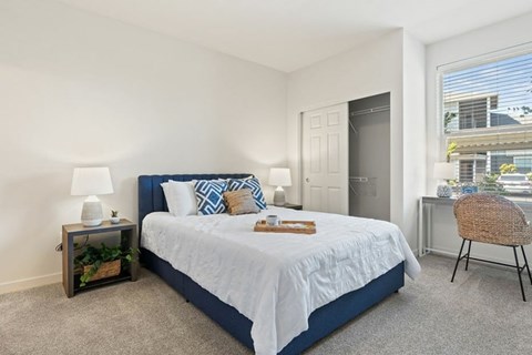 A bedroom with a large bed and a chair.