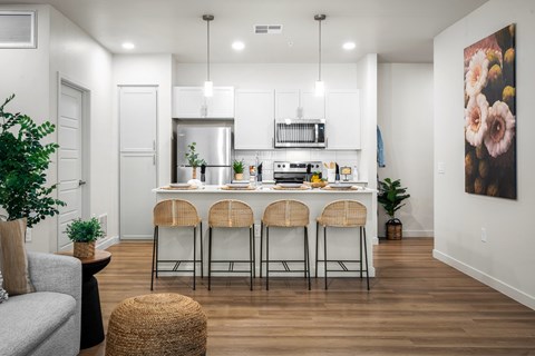 A modern kitchen with a bar stool set.
