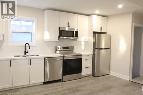 A modern kitchen with white cabinets and stainless steel appliances.