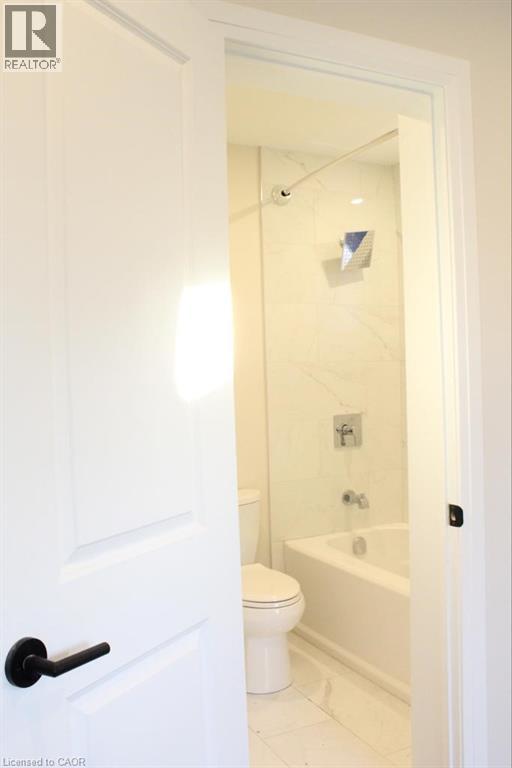 A white bathroom with a toilet, tub and sink.