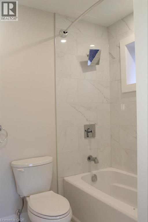 A white toilet is next to a bathtub in a bathroom.