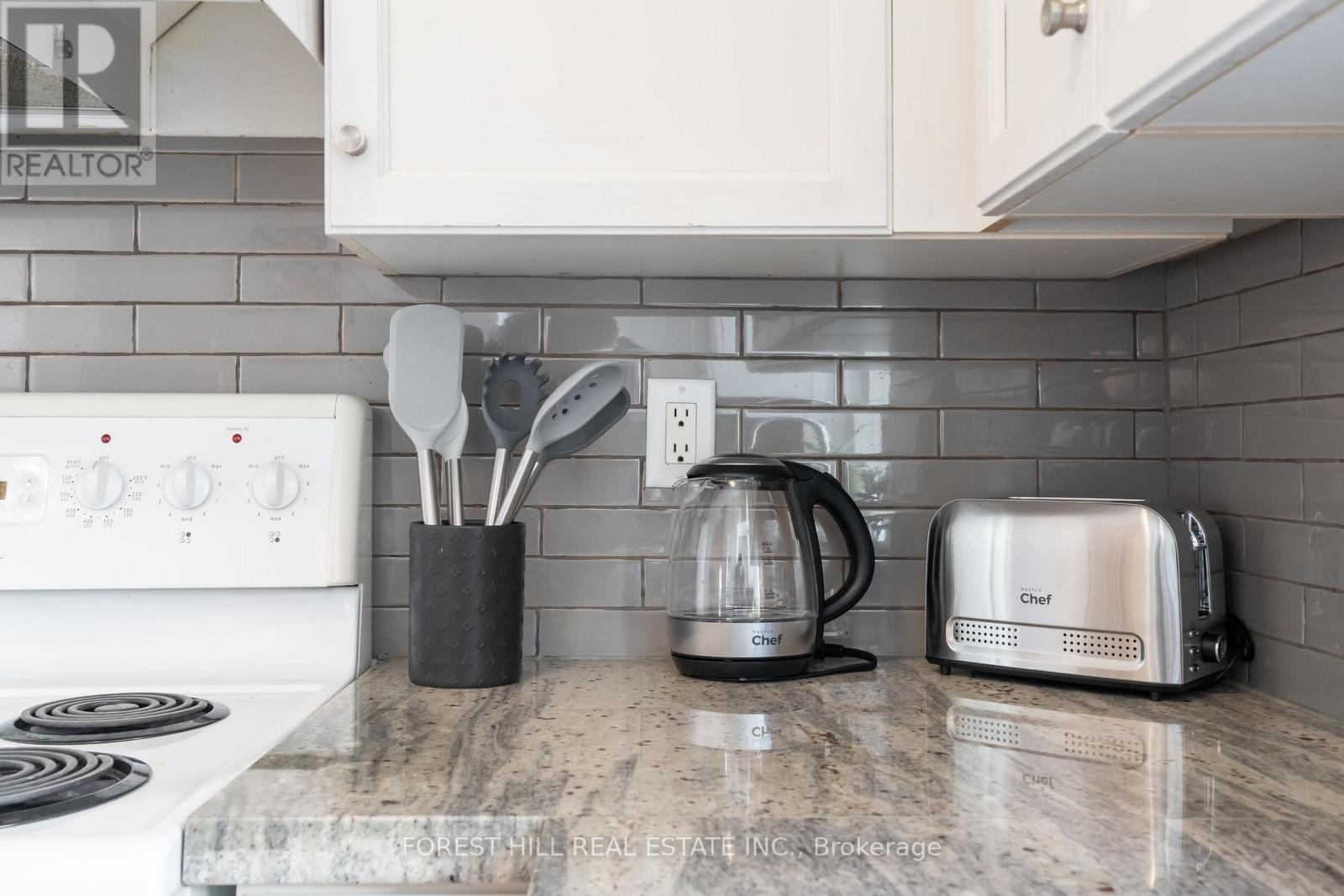 A kitchen counter with a toaster, a coffee maker, and utensils.
