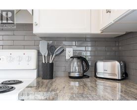 A kitchen counter with a toaster, a coffee maker, and utensils.