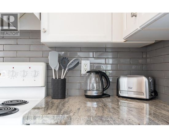 A kitchen counter with a toaster, a coffee maker, and utensils.