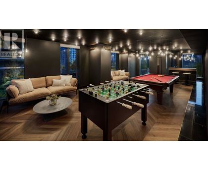 A pool table is in the middle of a room with a couch and a coffee table.