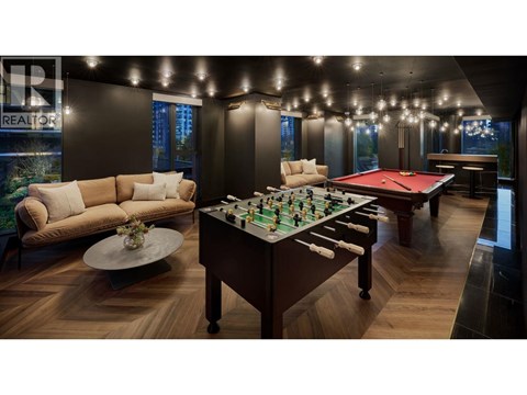 A pool table is in the middle of a room with a couch and a coffee table.