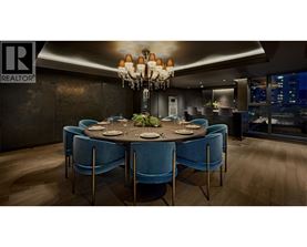 A dining room with a round table and blue chairs.
