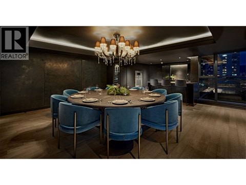 A dining room with a round table and blue chairs.