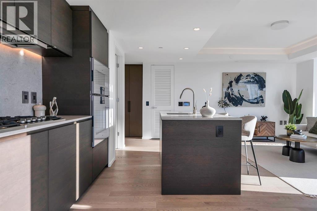 A modern kitchen with dark wood cabinetry and a white stove top.