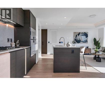 A modern kitchen with dark wood cabinetry and a white stove top.