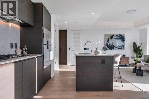 A modern kitchen with dark wood cabinetry and a white stove top.