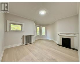 A spacious room with a fireplace and a window.
