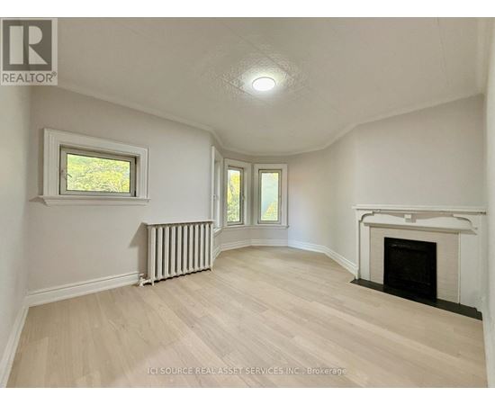 A spacious room with a fireplace and a window.