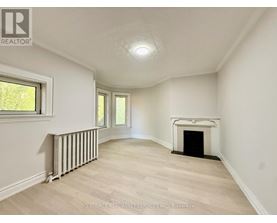 A spacious room with a fireplace and a window.