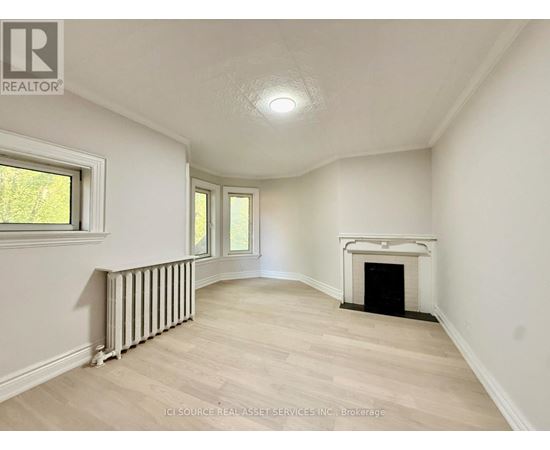 A spacious room with a fireplace and a window.