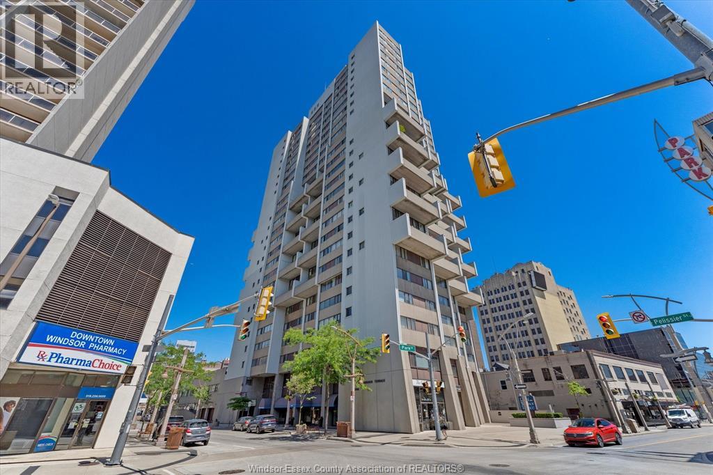 A street view of a city with a tall building in the center.